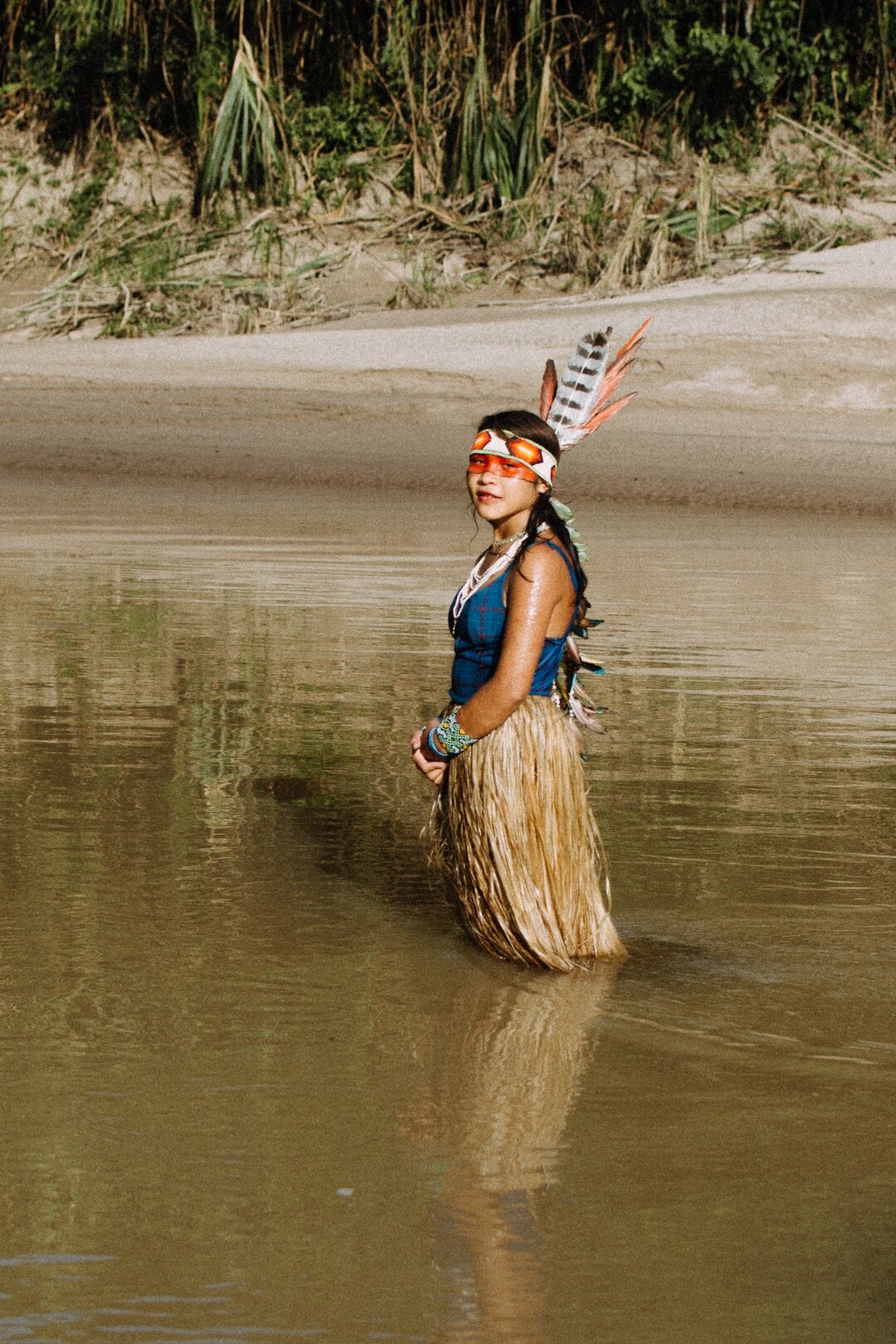 Portrait wearing a feathered headdress in golden light