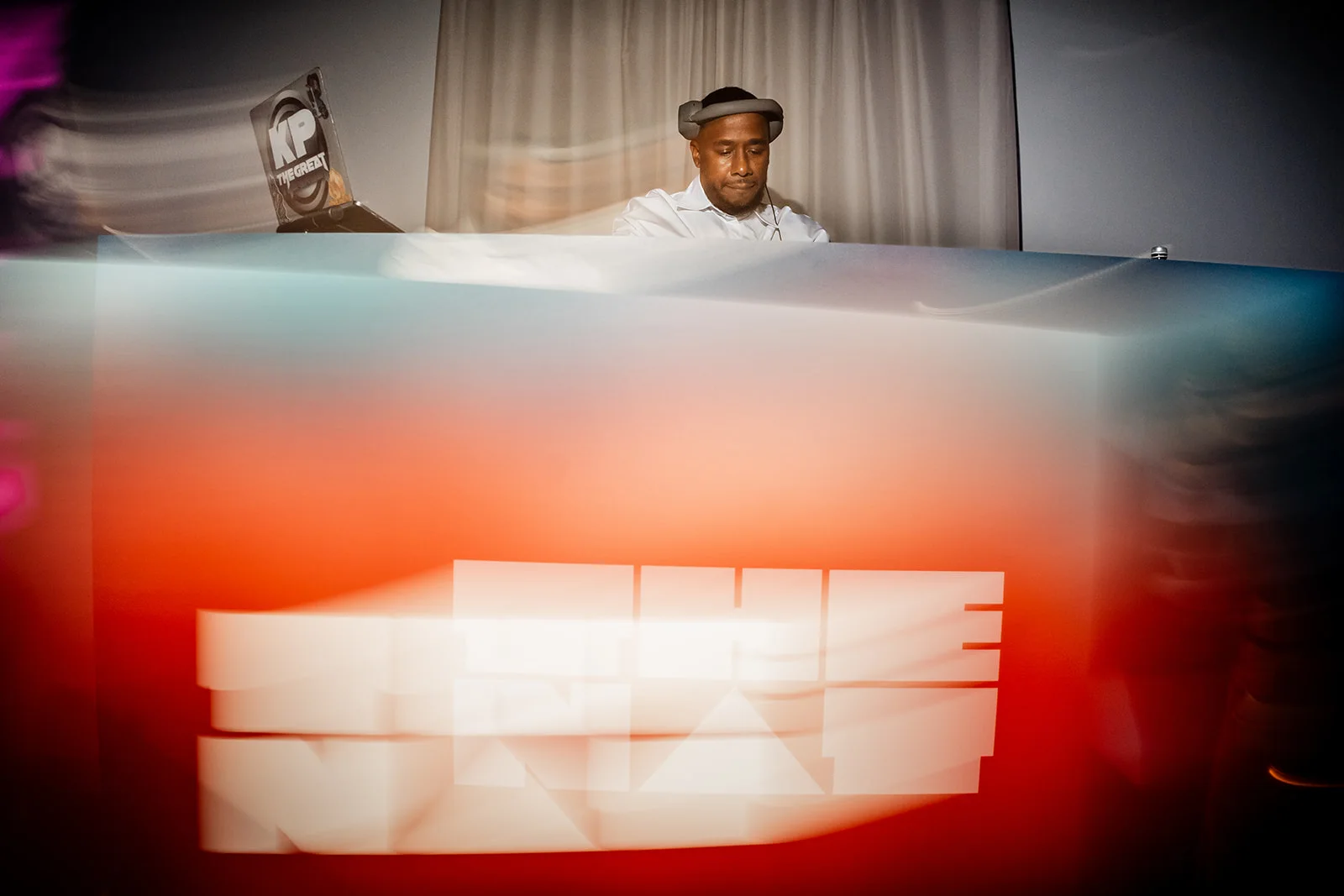 DJ KP The Great on the decks behind THE NAT logo at NATCAP: Coral Rave.